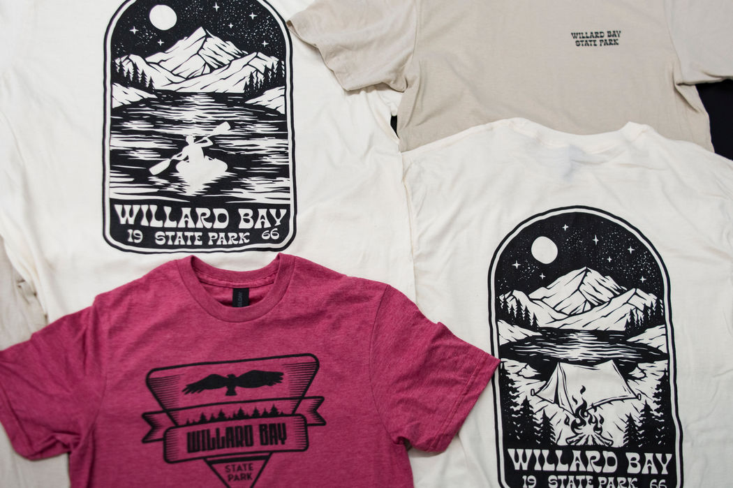 Multiple color t-shirts with black screen printed designs.