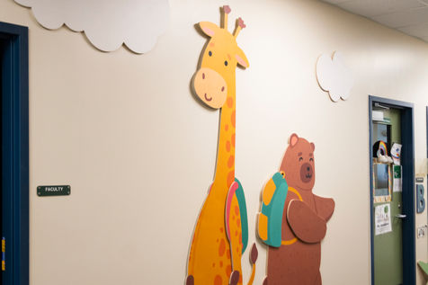 Custom wooden giraffe and bear graphics, shown in preschool hallway. 