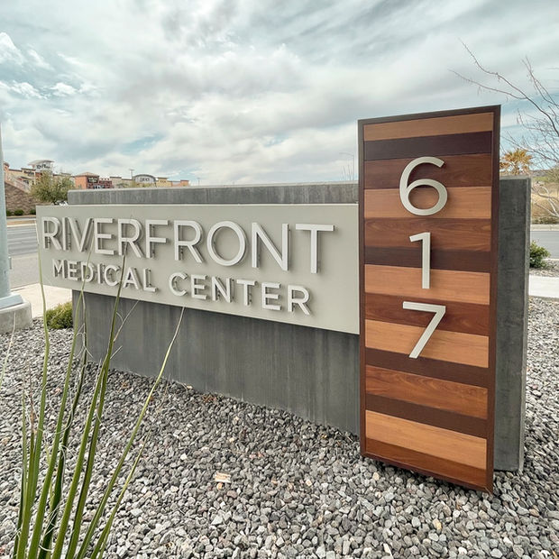 "Riverfront Medical Center, 617" silver dimensional lettering, mounted to wooden paneling that make up the sign.