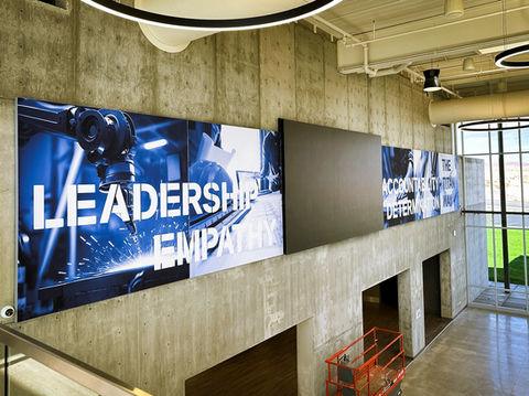 Vinyl wall graphic to the side of an interior stairway, reading "Leadership, Empathy" 