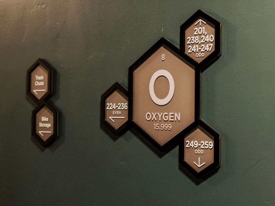 Wayfinding stylized like the table of elements, with floor numbers named after the associated element, and room numbers surrounding the floor number like atoms.