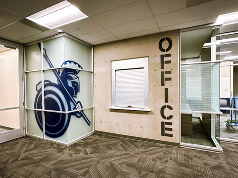 Custom printed privacy vinyl with the titan warrior graphic, with vertica vinyl lettering reading "Office" in a custom font.