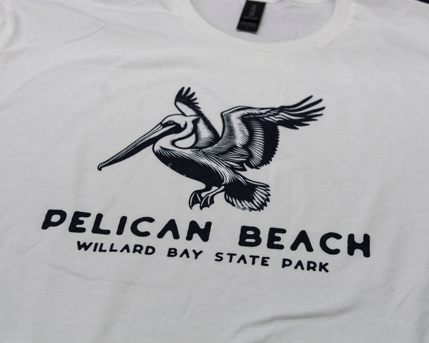 A black screen printed design featuring a pelican and the words "pelican beach" 
