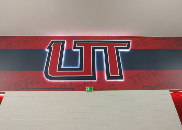 Backlit "UT" multilayered logo on blue and red vinyl wall wrap.  