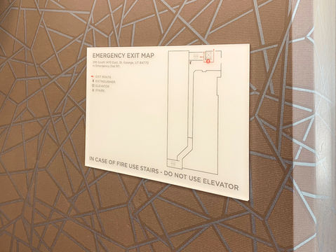 "Emergency Evacuation Map" printed onto frosted acrylic, black outlined floorplan with a red evacuation path.