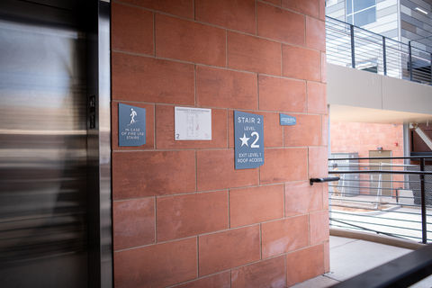 Elevator ADA signage made from blue painted acrylic.