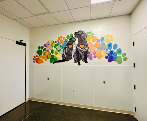 Cat and dog word art, each with an orange heart, sitting in front of colorful paw print artwork.
