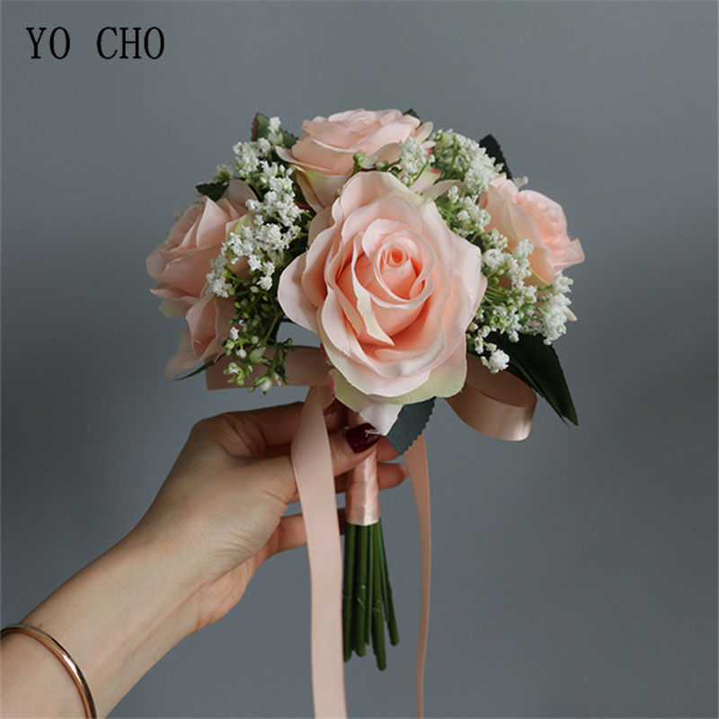 Thumbnail: Hand holding a pink silk rose and baby's breath bouquet