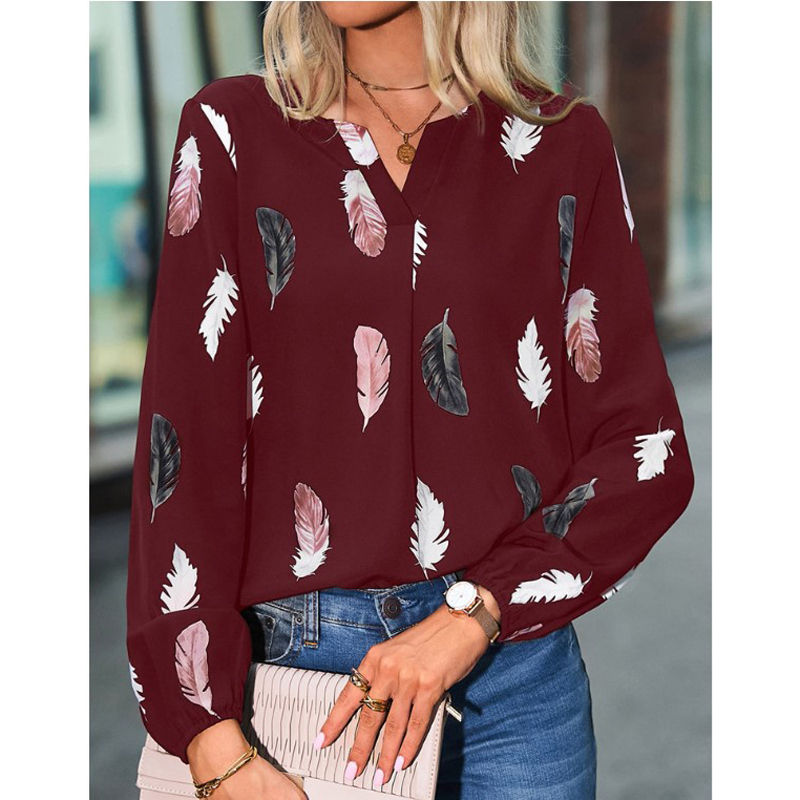Thumbnail: Woman wearing a burgundy long-sleeve blouse with feather print
