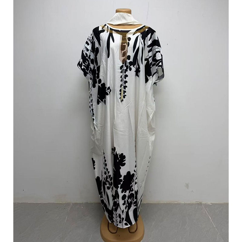 Thumbnail: White Abaya with black floral patterns on a mannequin.