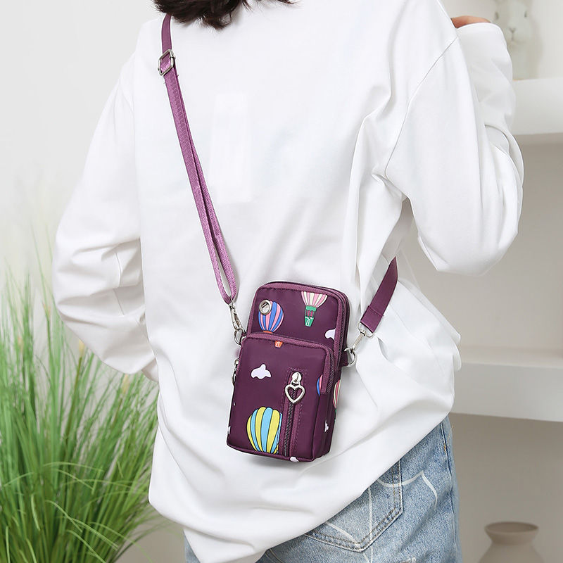 Thumbnail: Woman wearing a slim nylon crossbody purse with patterns