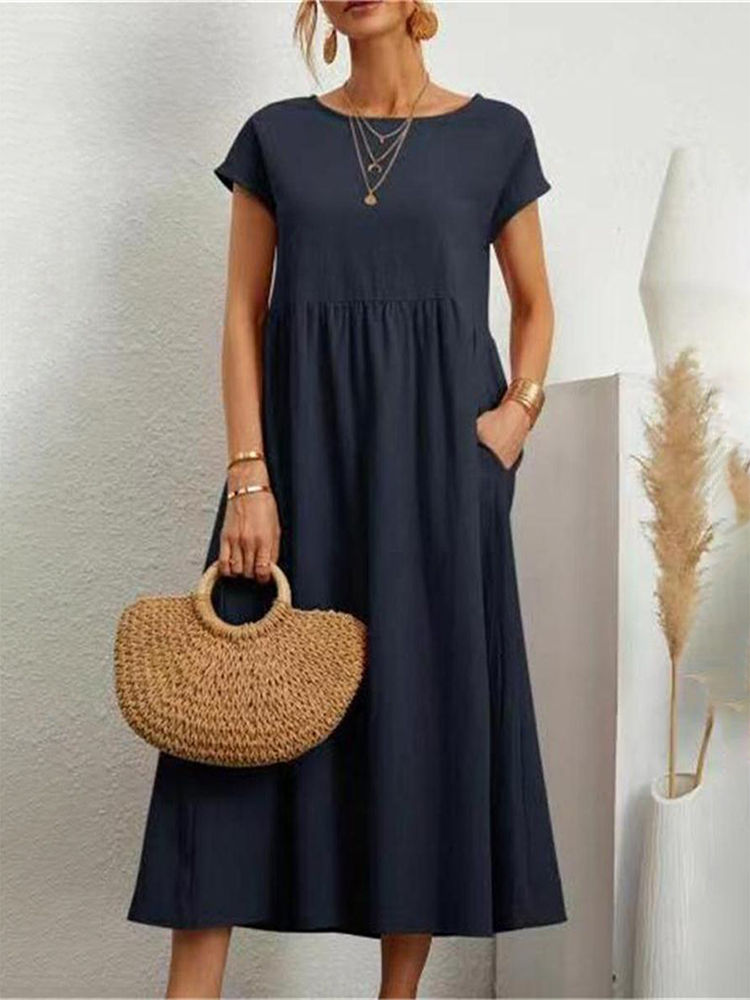 Thumbnail: Woman in navy summer dress with straw handbag
