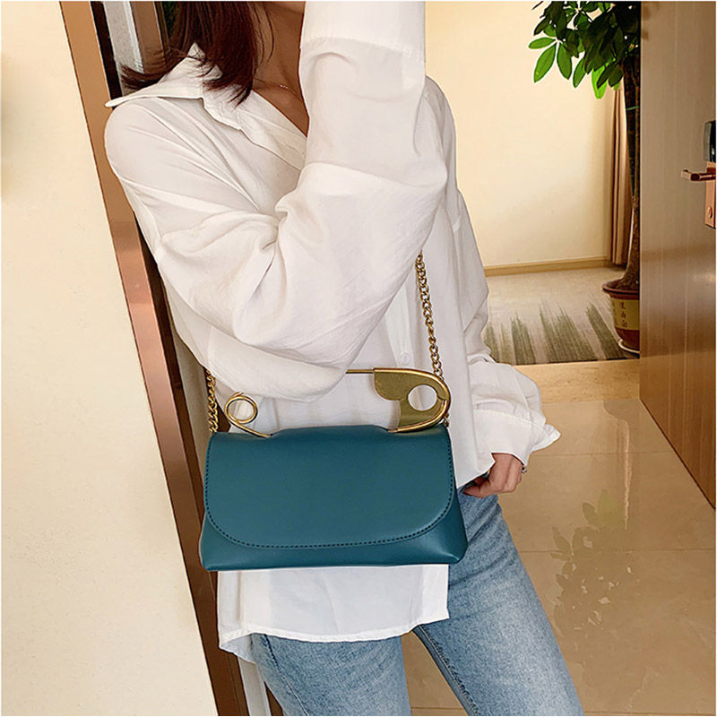 Thumbnail: Woman wearing a teal PU leather flap shoulder bag.