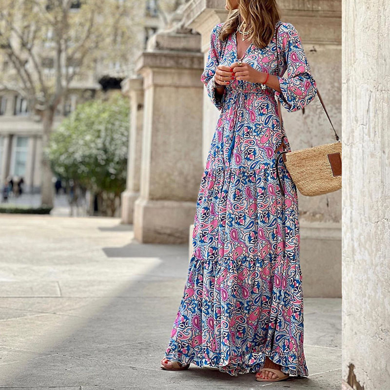 Thumbnail: Woman in floral blue and pink maxi dress with straw bag