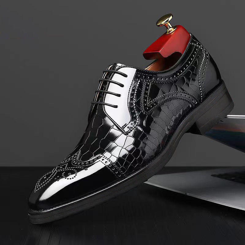 Thumbnail: Polished black leather men's dress shoe with brogue details.