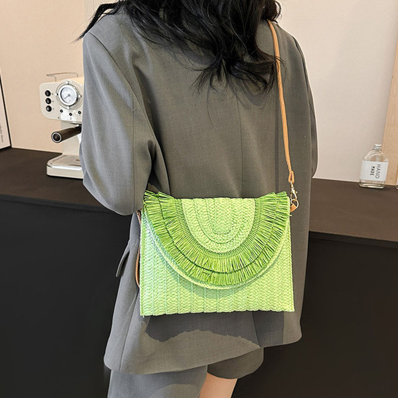 Thumbnail: Green handmade weave clutch bag with summer flap worn by a woman.