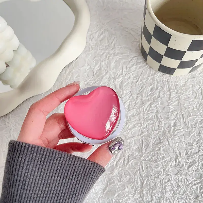 Thumbnail: Pink glass heart magnetic phone grip held in hand
