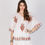 Thumbnail: Woman wearing embroidered white top and skirt, with detailed patterns, Adine.