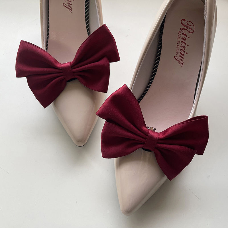 Thumbnail: Pair of burgundy bow shoe clips on beige high heels