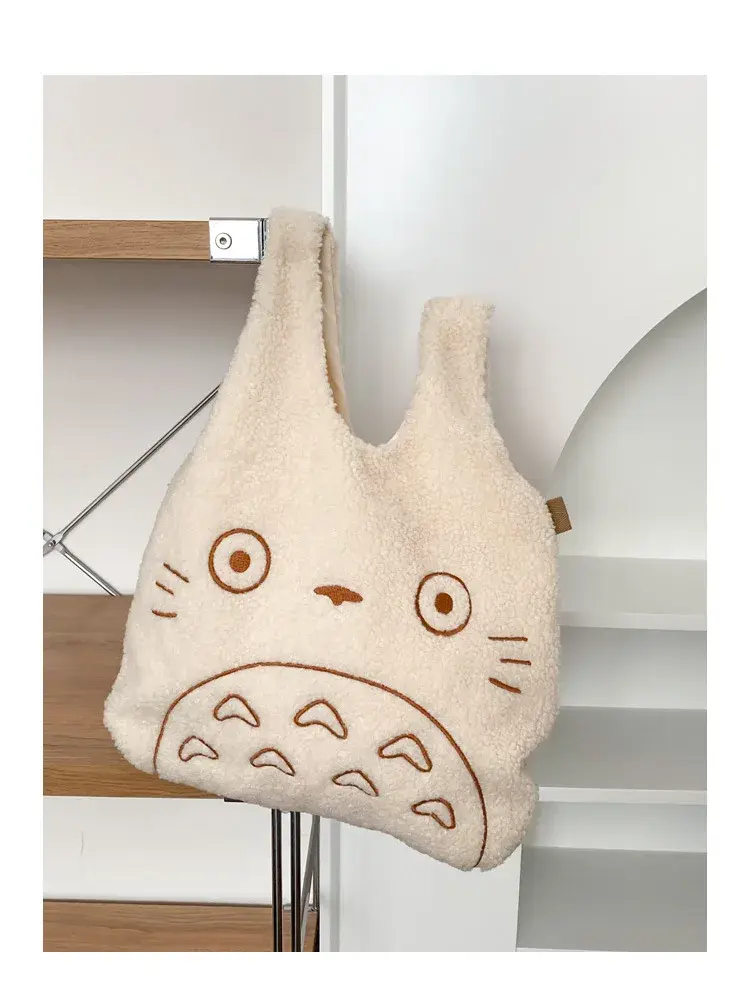 Thumbnail: Beige Totoro tote bag hanging on a shelf.