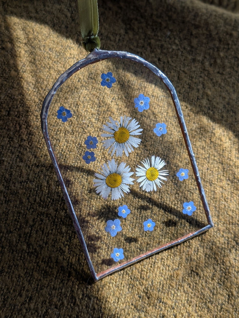 Daisys and forget me not flowers pressed into glass