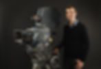 Man standing behind a large vintage movie camera