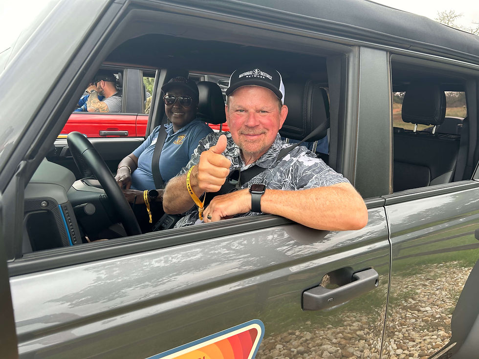 man and woman in car, man giving a thumbs up