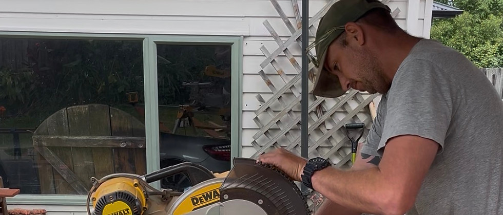 Experienced builder cutting wood with a miter saw