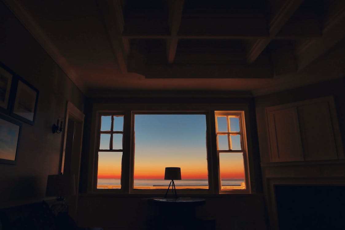 A lamp glowing beside a window in a quiet room — the texture of a night spent thinking.