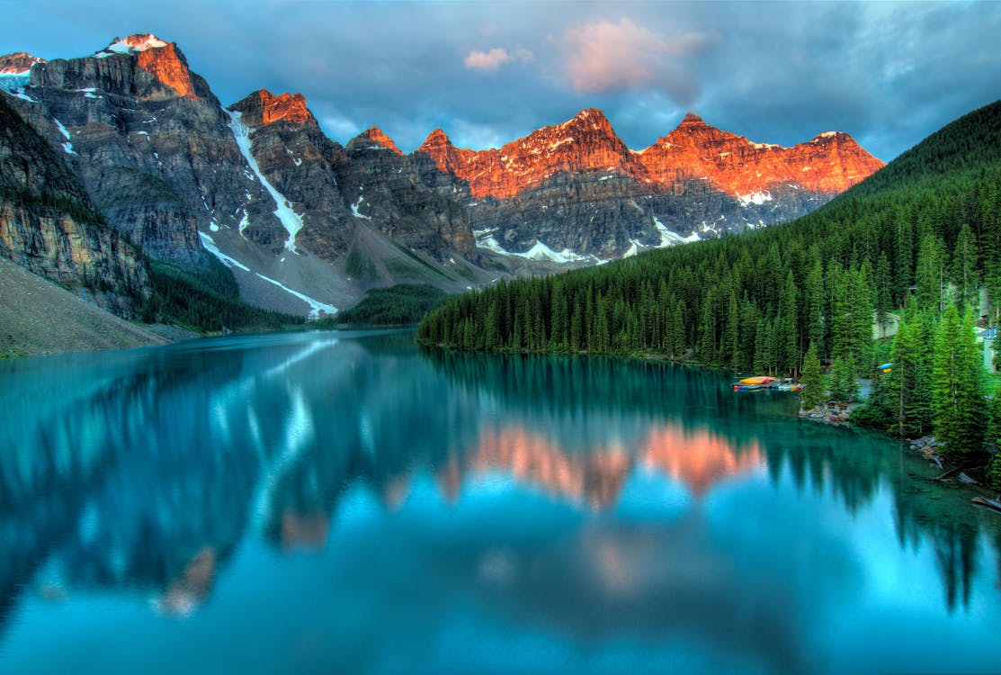 A stunning alpine lake surrounded by mountains and forest — the kind of landscape people build a life around.