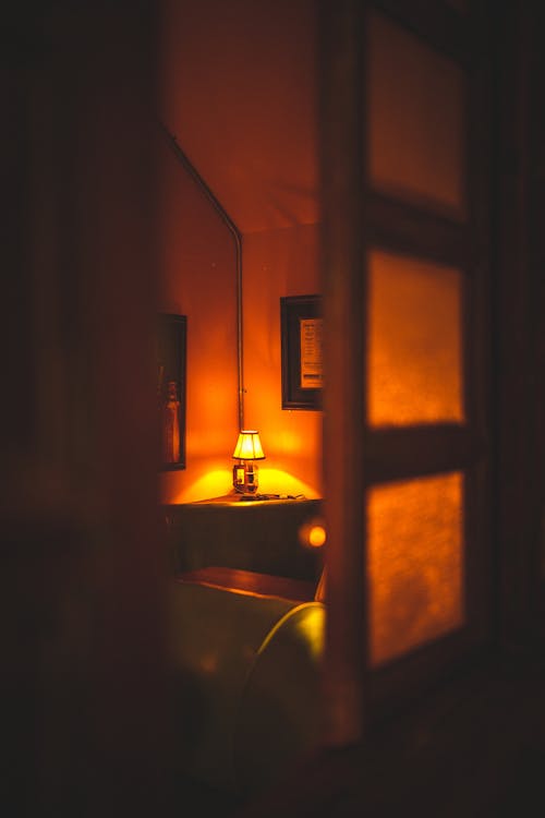 A lamp casting warm yellow light in a dim room — soft, calm, reassuring.