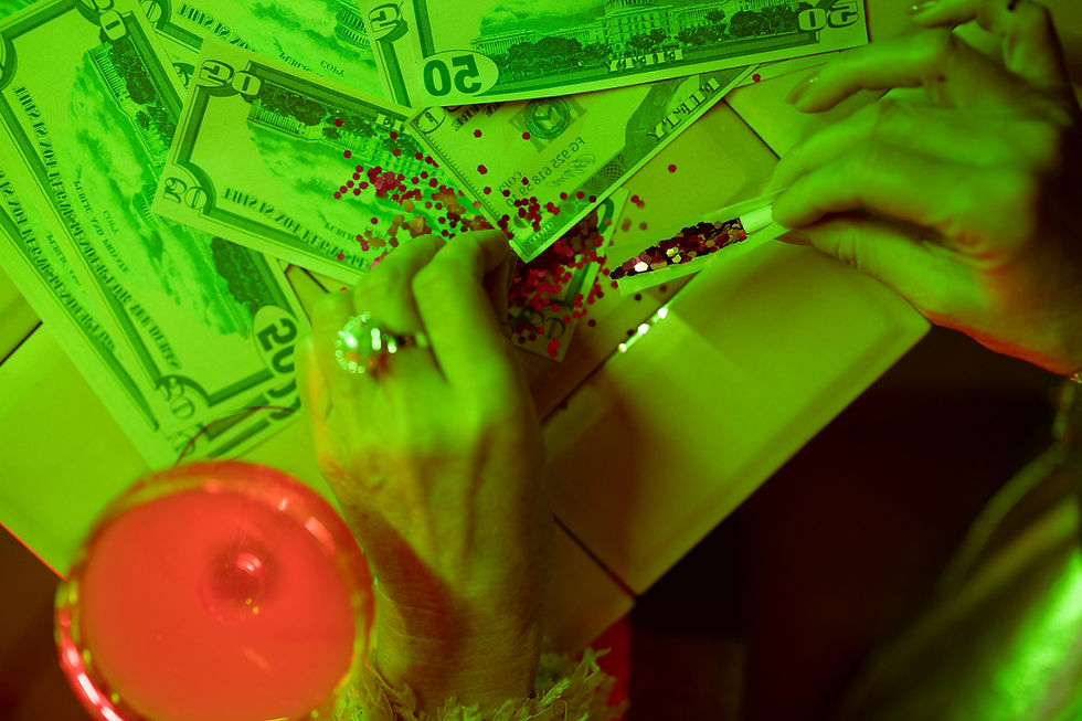 sur une table il y a de l'argent, des paillettes et un cocktail
