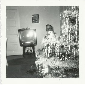 Man poses with dog between Christmas tree and TV, 1954.