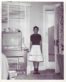 Girl, dressed up, poses next to TV, 8 X 10 size, circa 1952-57.