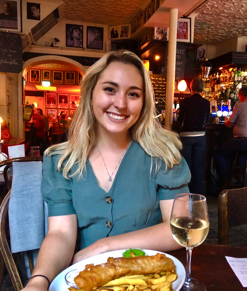 Alex enjoying classic British fish and chips with a glass of wine