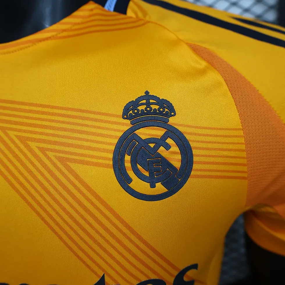 Thumbnail: Close-up of Real Madrid crest on a yellow football shirt