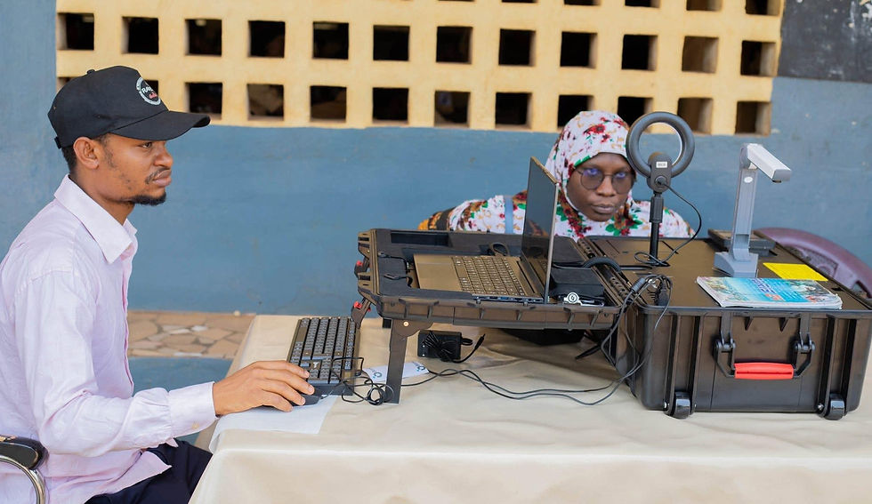 Field team operating a portable biometric enrollment kit at a remote registration site