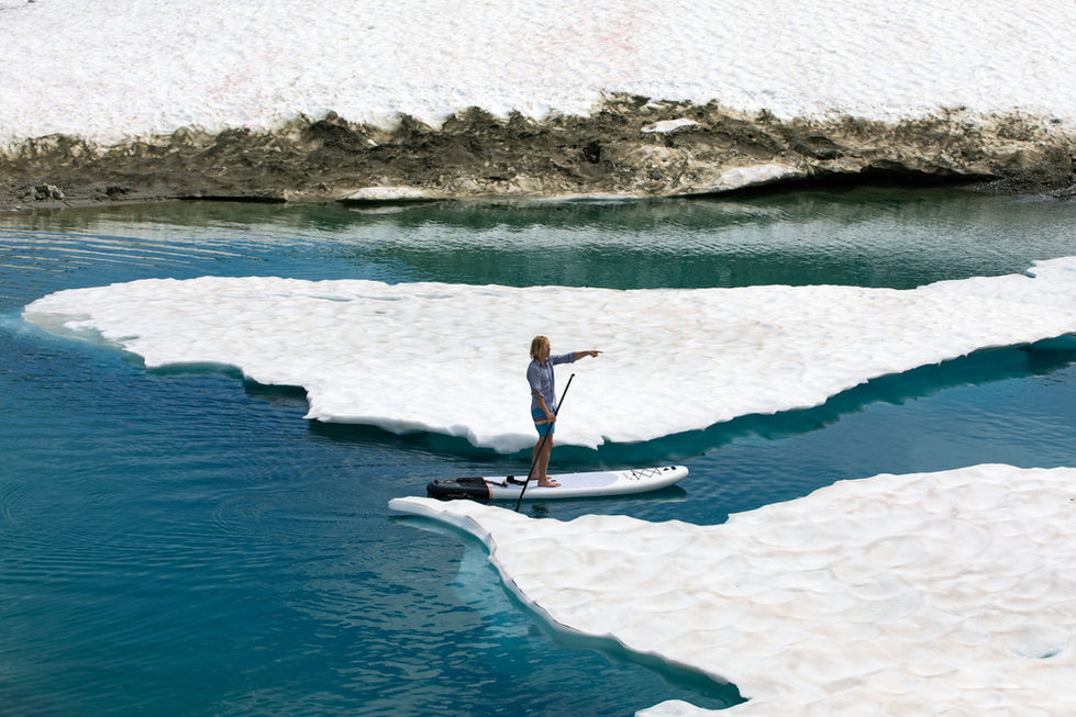 Colorful photo of a paddleboarder between icebergs