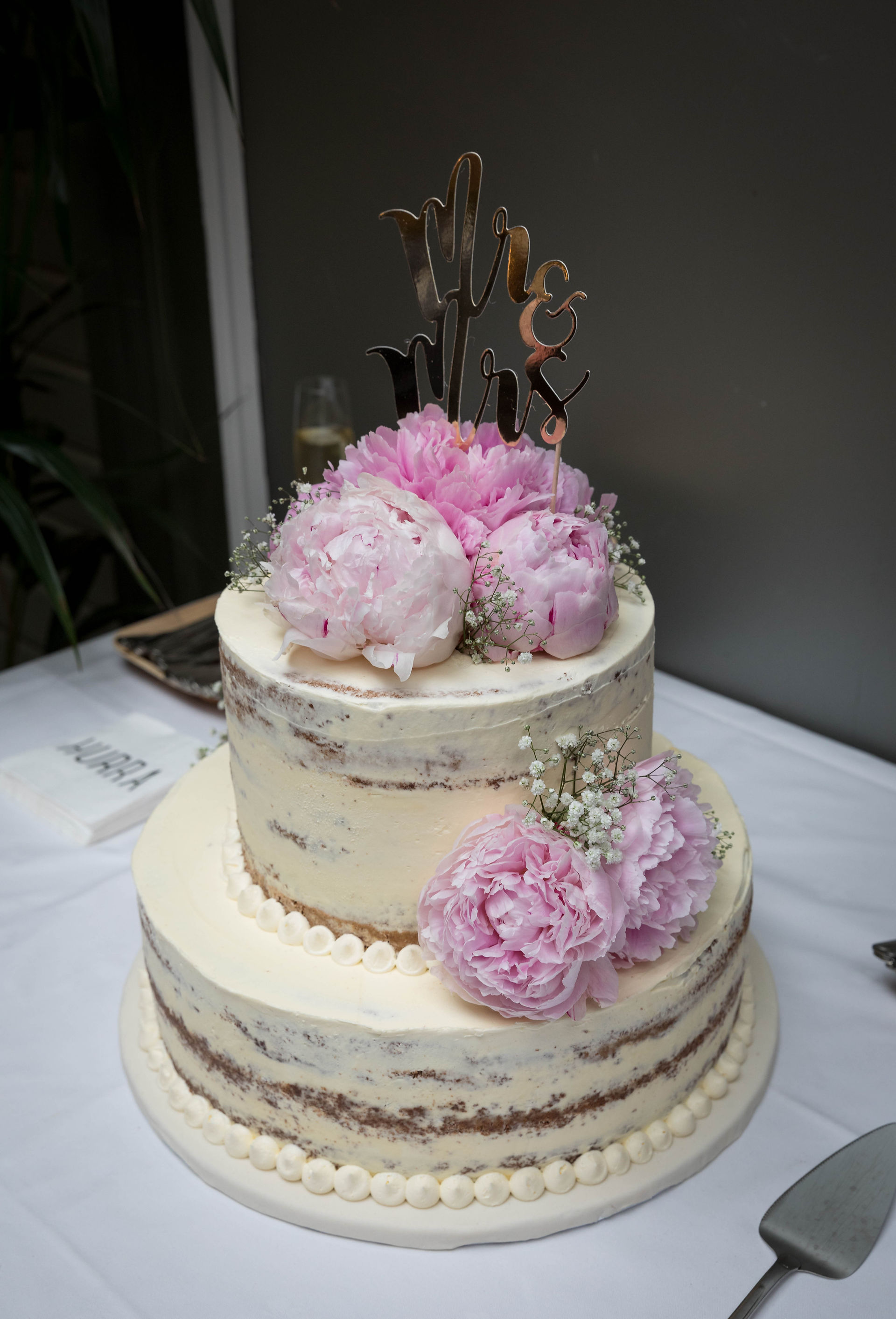 Kake med to etasjer og rosa peoner