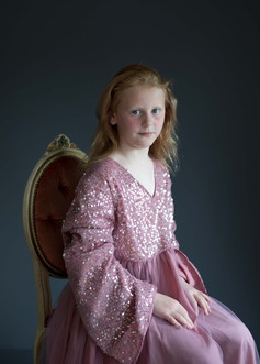 Studioportrett av jente i glitrende rosa kjole
