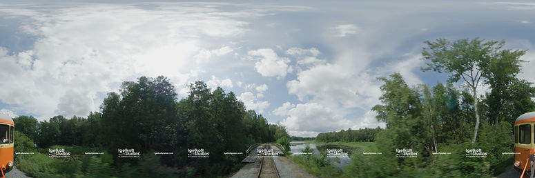 16K360 equirectangular train driving plate captured by Igelkott Studios for in-camera VFX, showing a summer landscape with trees, clouds, and railway tracks for projection-based virtual production.