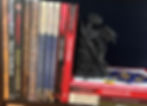 a dragon bookend holding up a series of old Dungeons & Dragons players handbooks