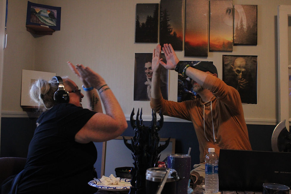 Two adults, smile and double high five over a gaming table.