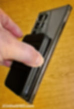 Anker 622 MagGo used as a phone stand, holding a smartphone upright with a webpage displayed.
