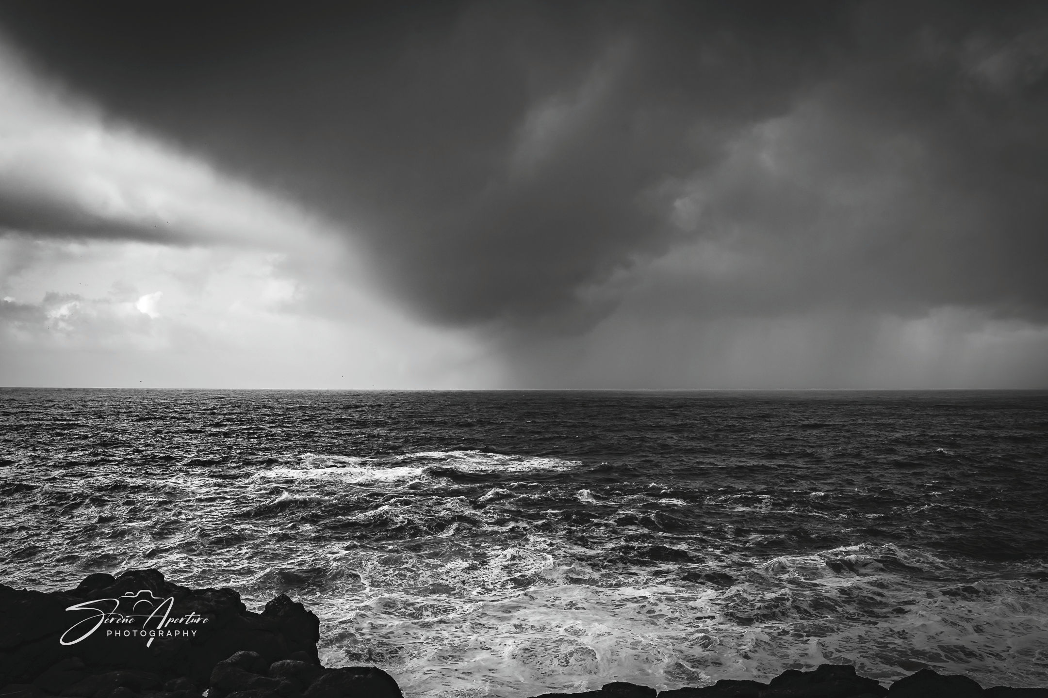 A split sky over the ocean shows a storm marching forwarded. Fine art perfect for home, office, lobbies, and more for all!
