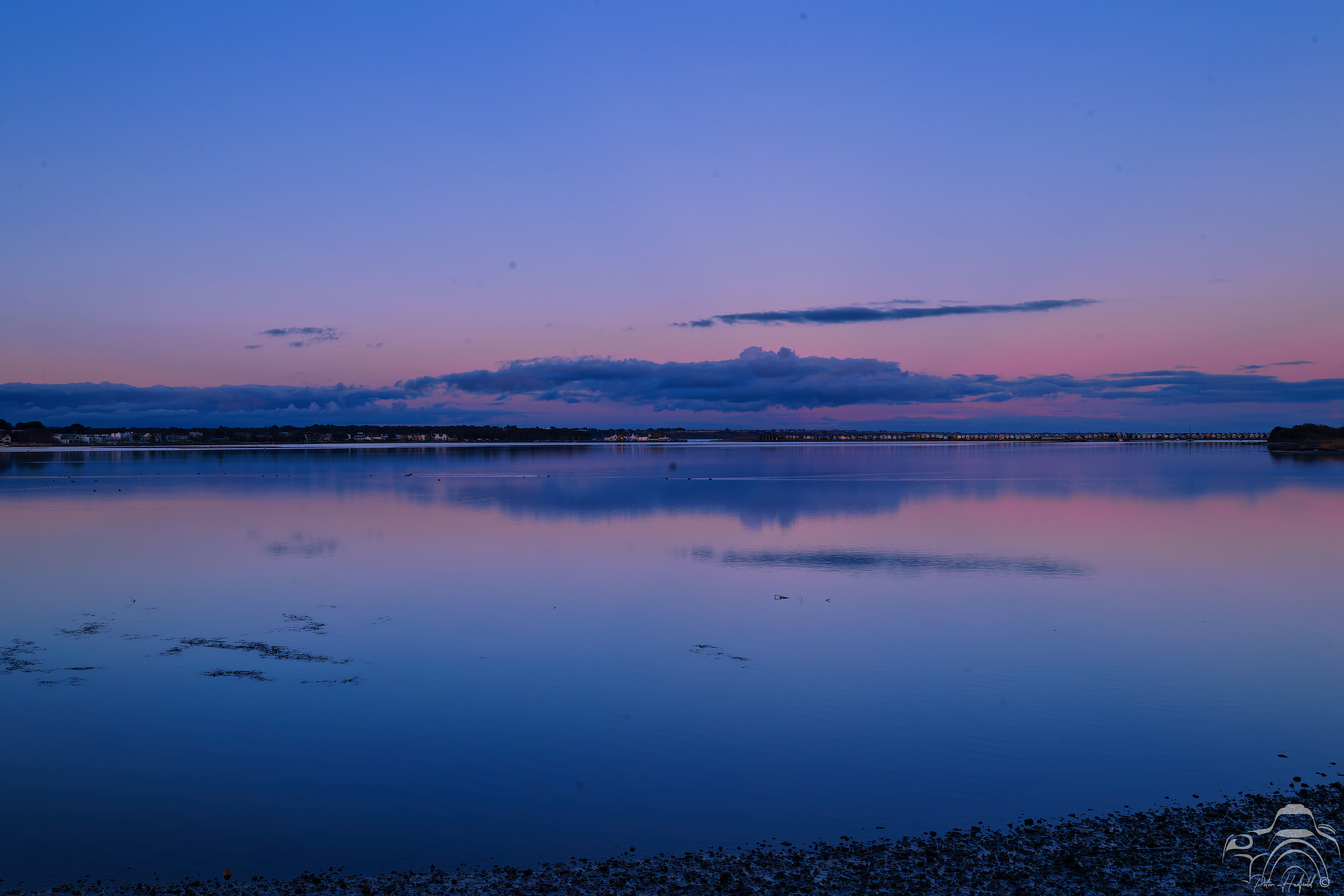 A reflection in the still water of Christchurch Harbour of a beautiful pastel blue /pink sky following sunset