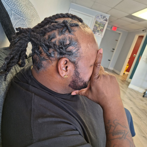 Man with Dreadlocks Braids, hand on face, in a salon setting, EUNICE.