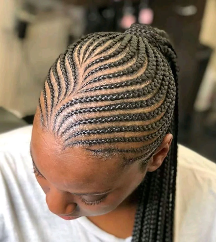 Woman with elegant cornrows hairstyle, hair pulled back into a ponytail.