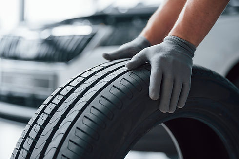 hands-only-mechanic-holding-tire-repair-garage-replacement-winter-summer-tires.jpg