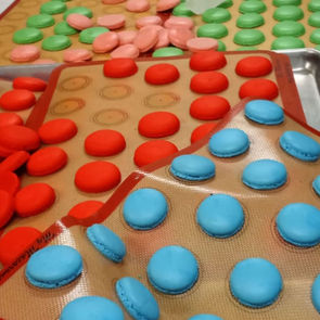 Colorful macarons on baking sheets